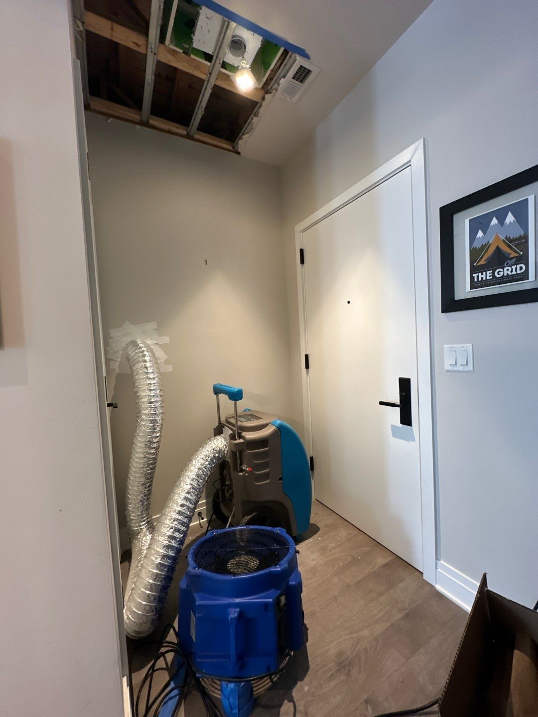 Dehumidifier and air movers deployed for moisture extraction during water damage restoration work.