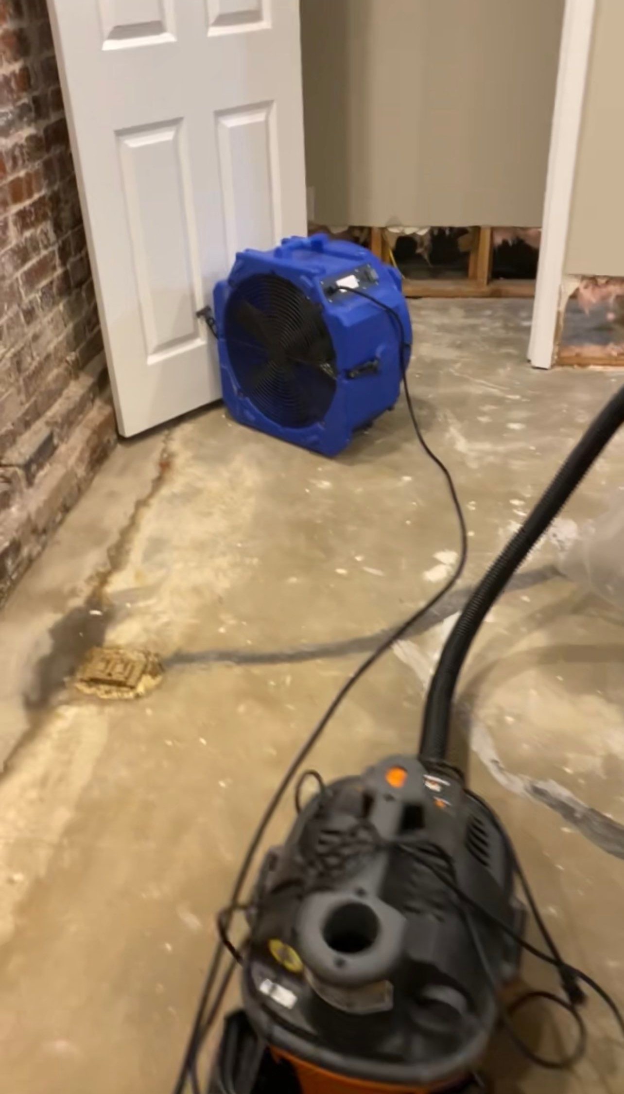 Standing water being removed with commercial extractors behind containment during restoration work.
