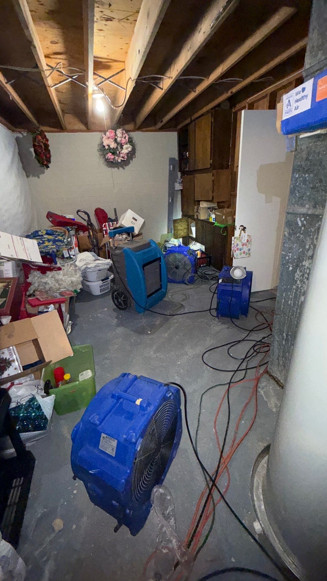 Mid-stage structural drying setup showing moisture control equipment and prepared ceiling cavity for remediation.