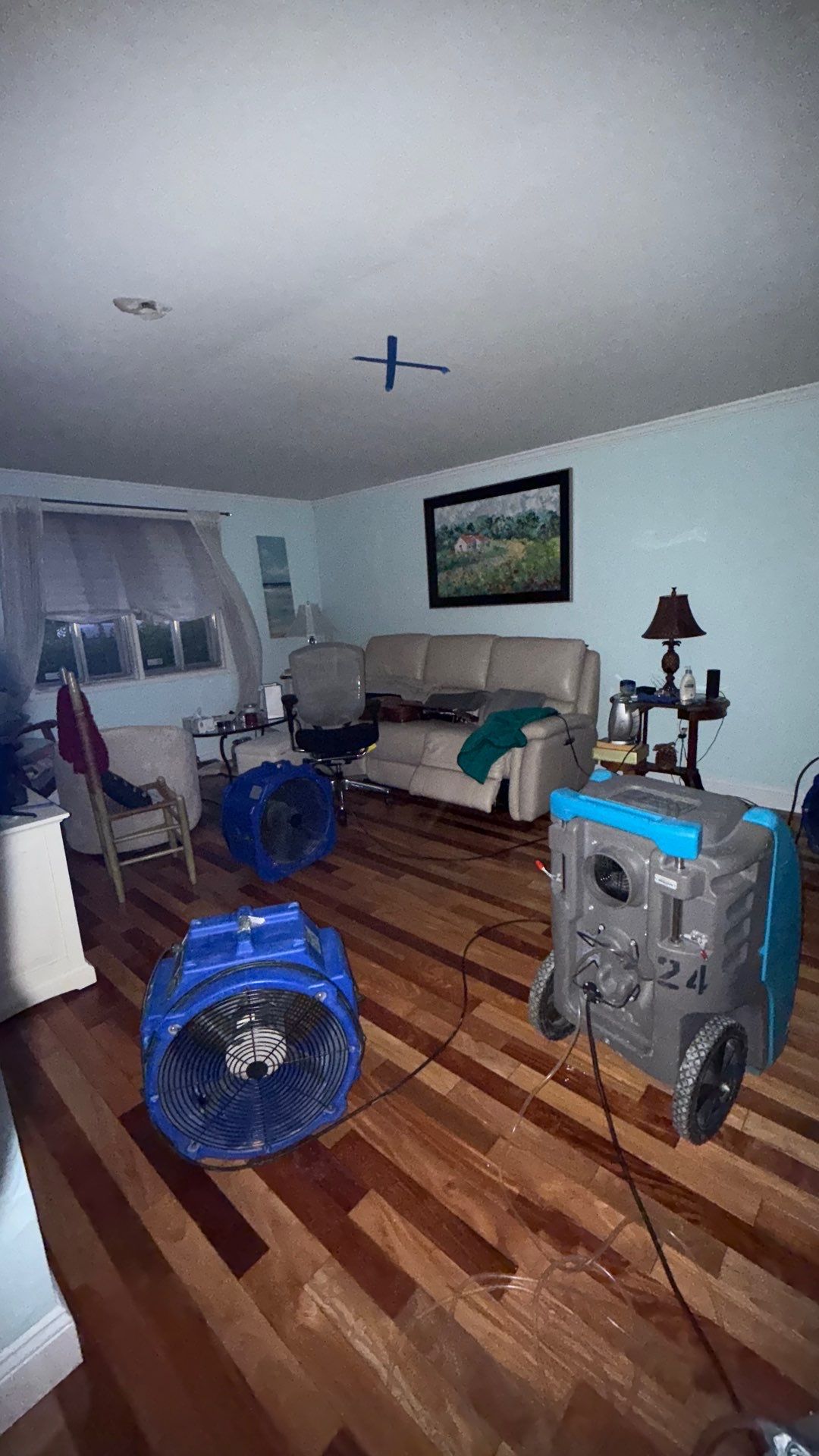 Containment barrier and dehumidifier in place during mold remediation work, ceiling framing under active drying.