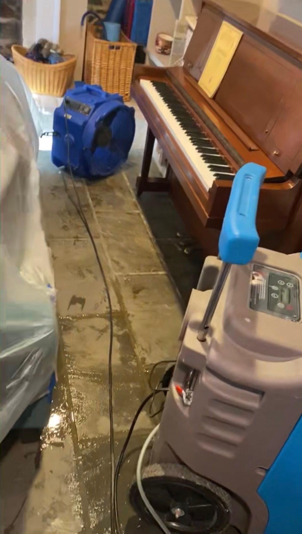 Standing water extraction underway in Washington water damage restoration, wet flooring visible.
