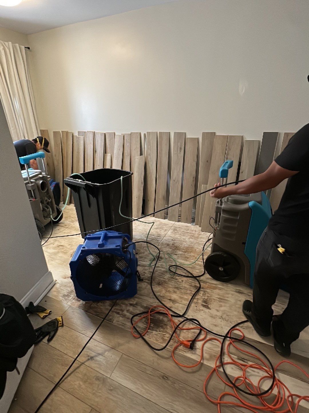 Wet carpet being removed and disposed during water extraction phase of restoration work.