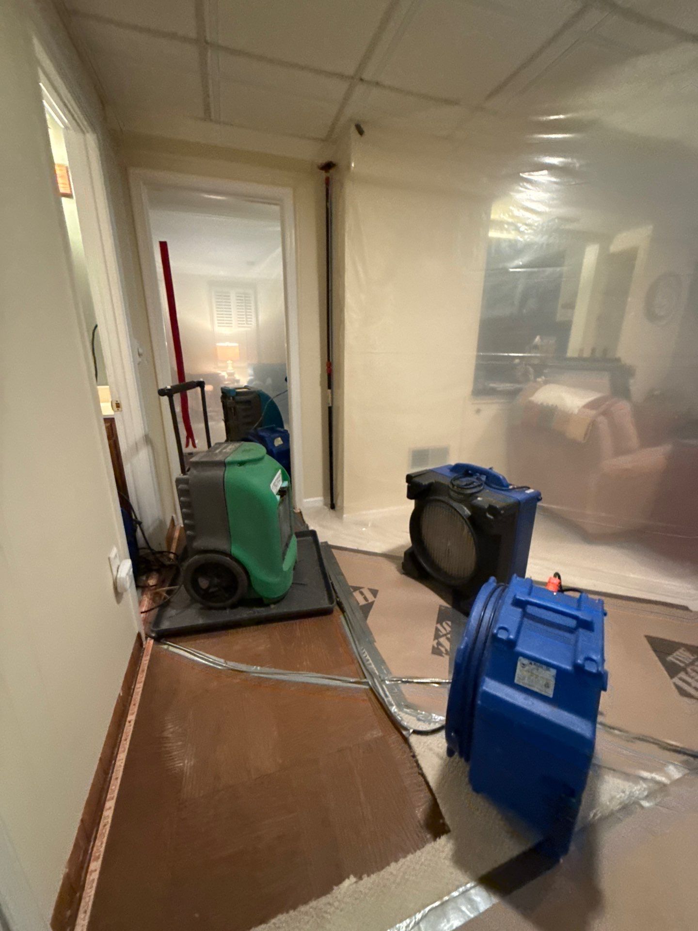 Standing water extraction underway in Silver Spring water damage restoration, wet flooring and wall base visible.