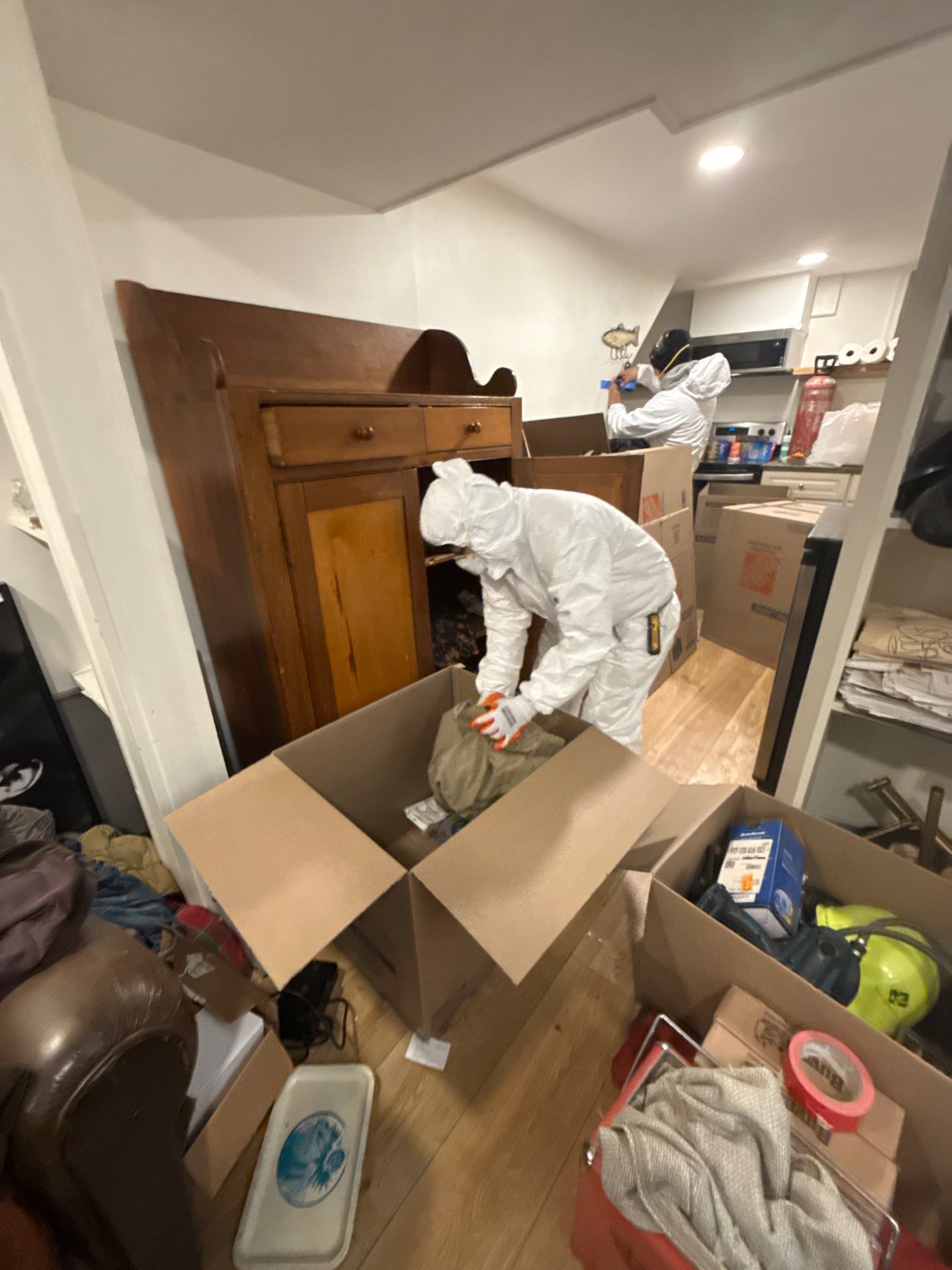 Protected furnishings and belongings arranged for safe storage during water damage restoration work.