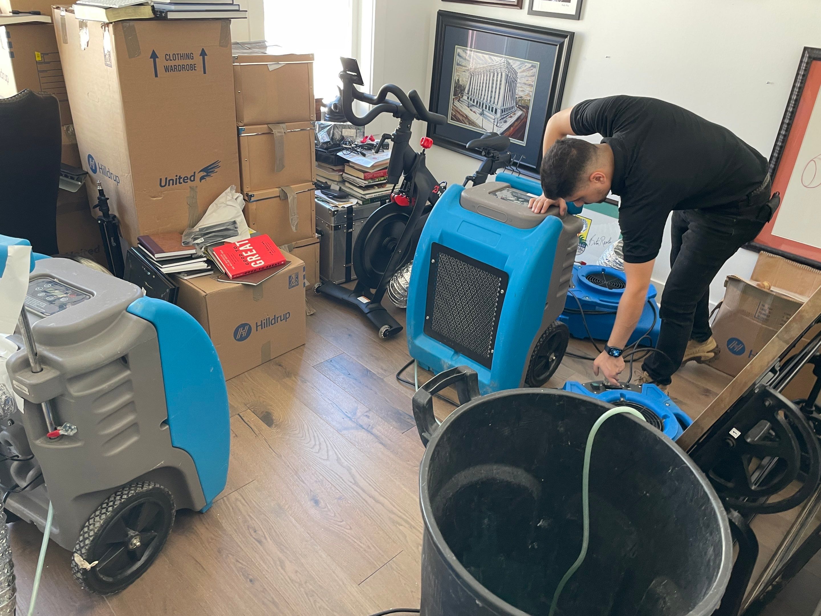 Standing water extraction underway in Bethesda water damage restoration, removal equipment positioned on flooded floor.