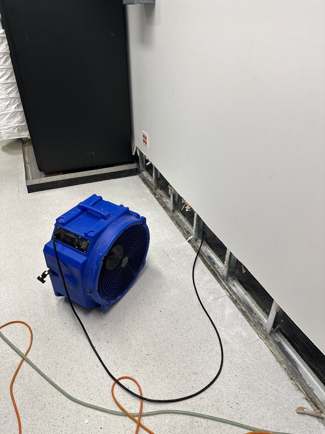Mid-stage drying setup showing continued dehumidification and air circulation across the restoration work area.