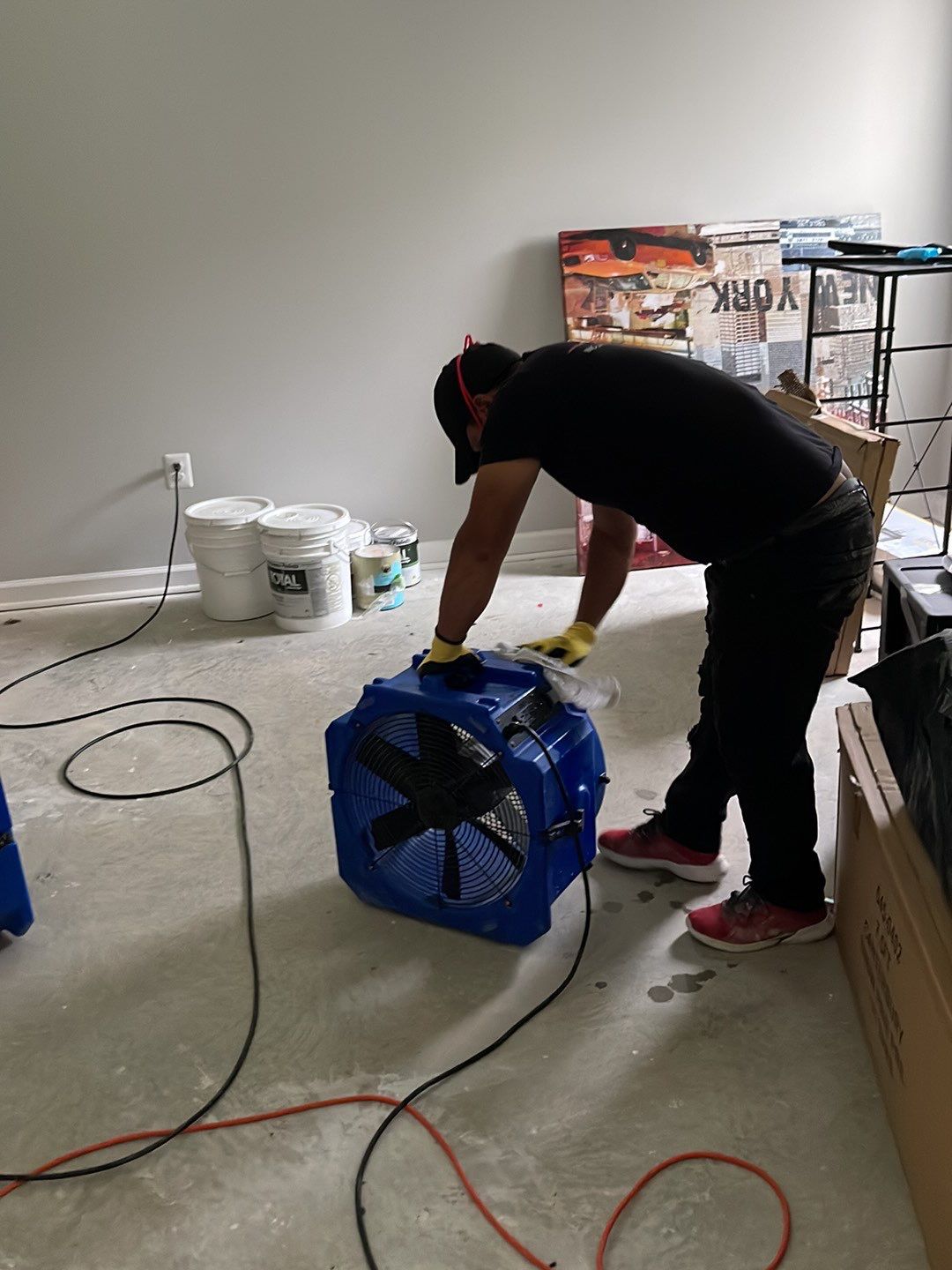 Standing water extraction underway in Brandywine water damage restoration, wet flooring visible.