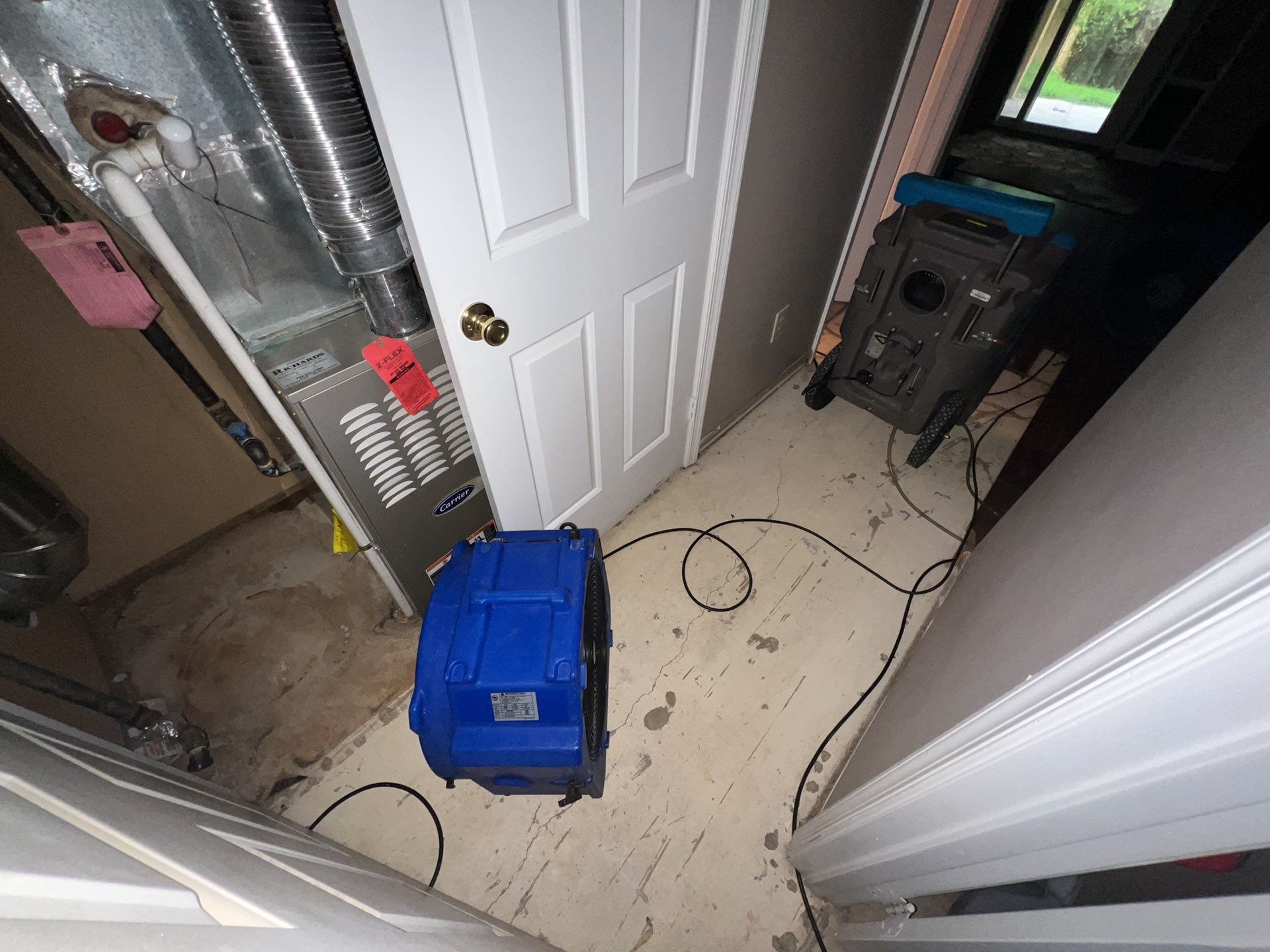 Dehumidifiers and air movers operating to dry building materials after water extraction.