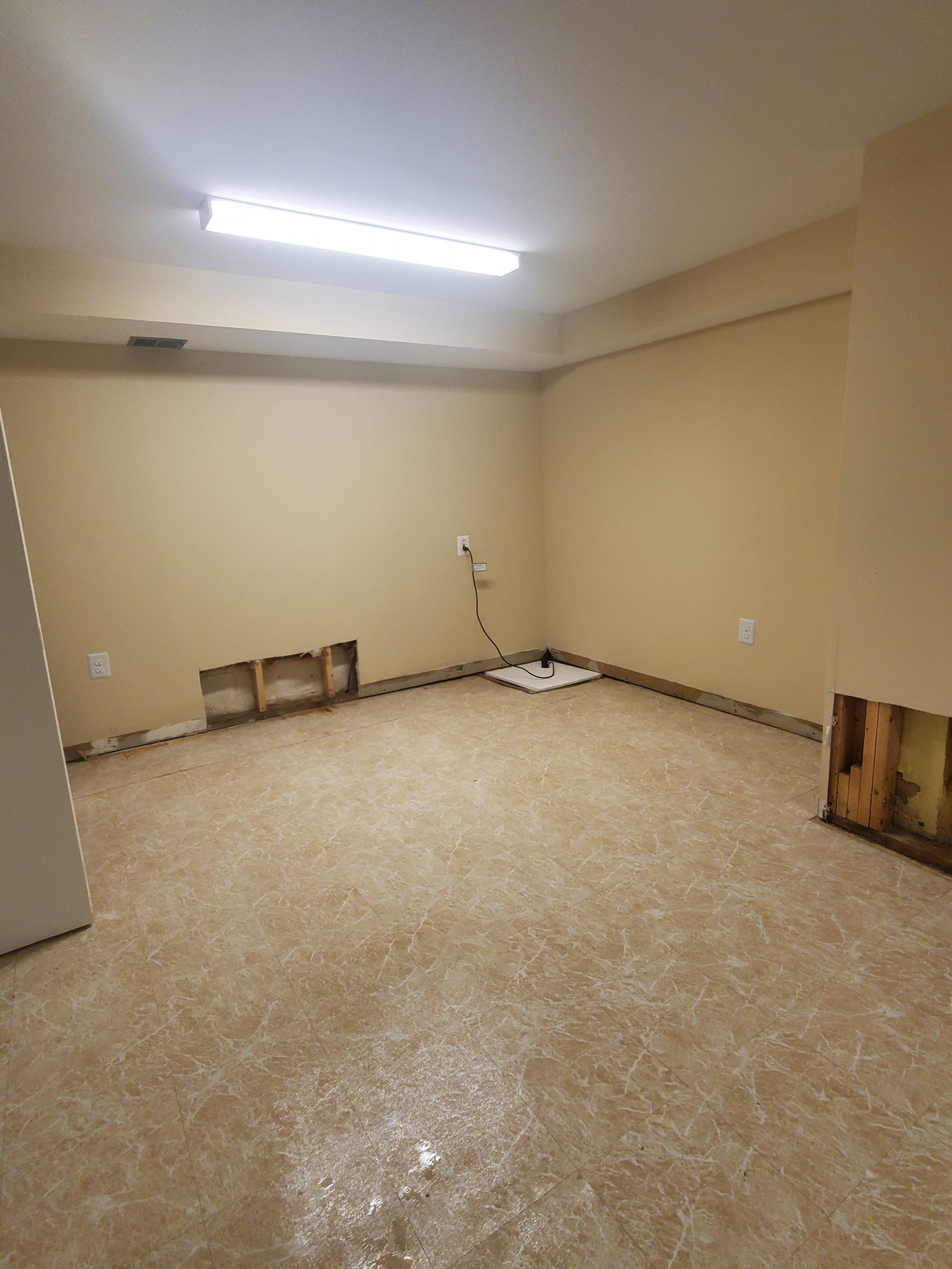 Mid-stage drying setup showing continued equipment placement for moisture extraction from walls and substructure.