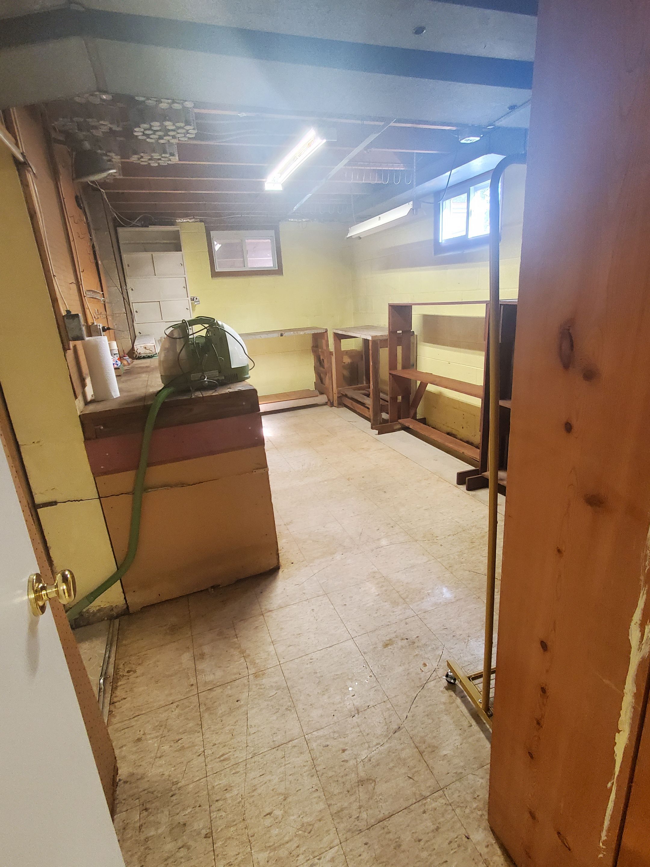 Standing water extraction underway in Silver Spring water damage restoration, removal equipment positioned on wet flooring.