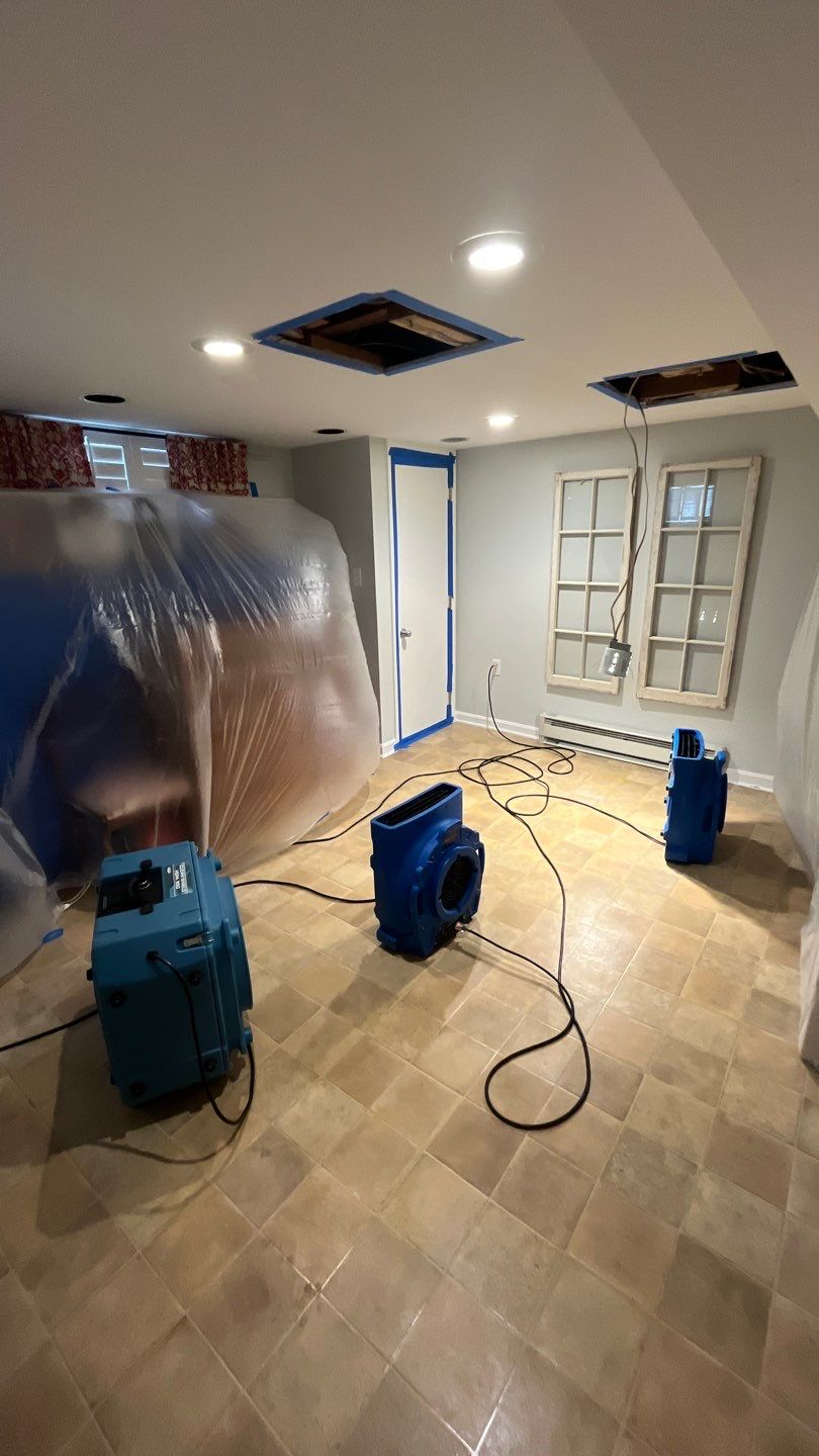Structural drying phase with dehumidifiers and air movers positioned throughout affected area.