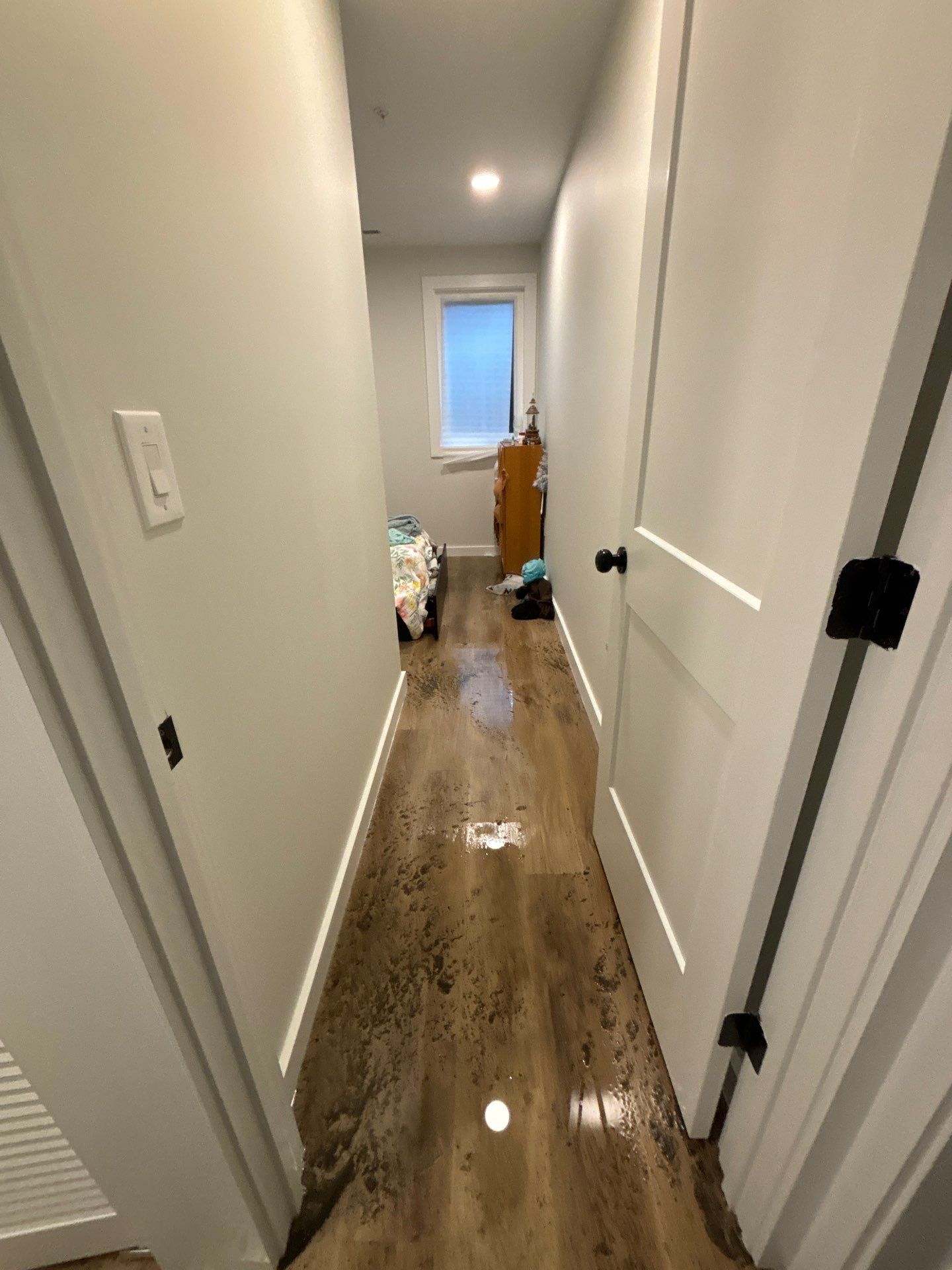Standing water extraction underway in Washington water damage restoration, wet flooring visible.