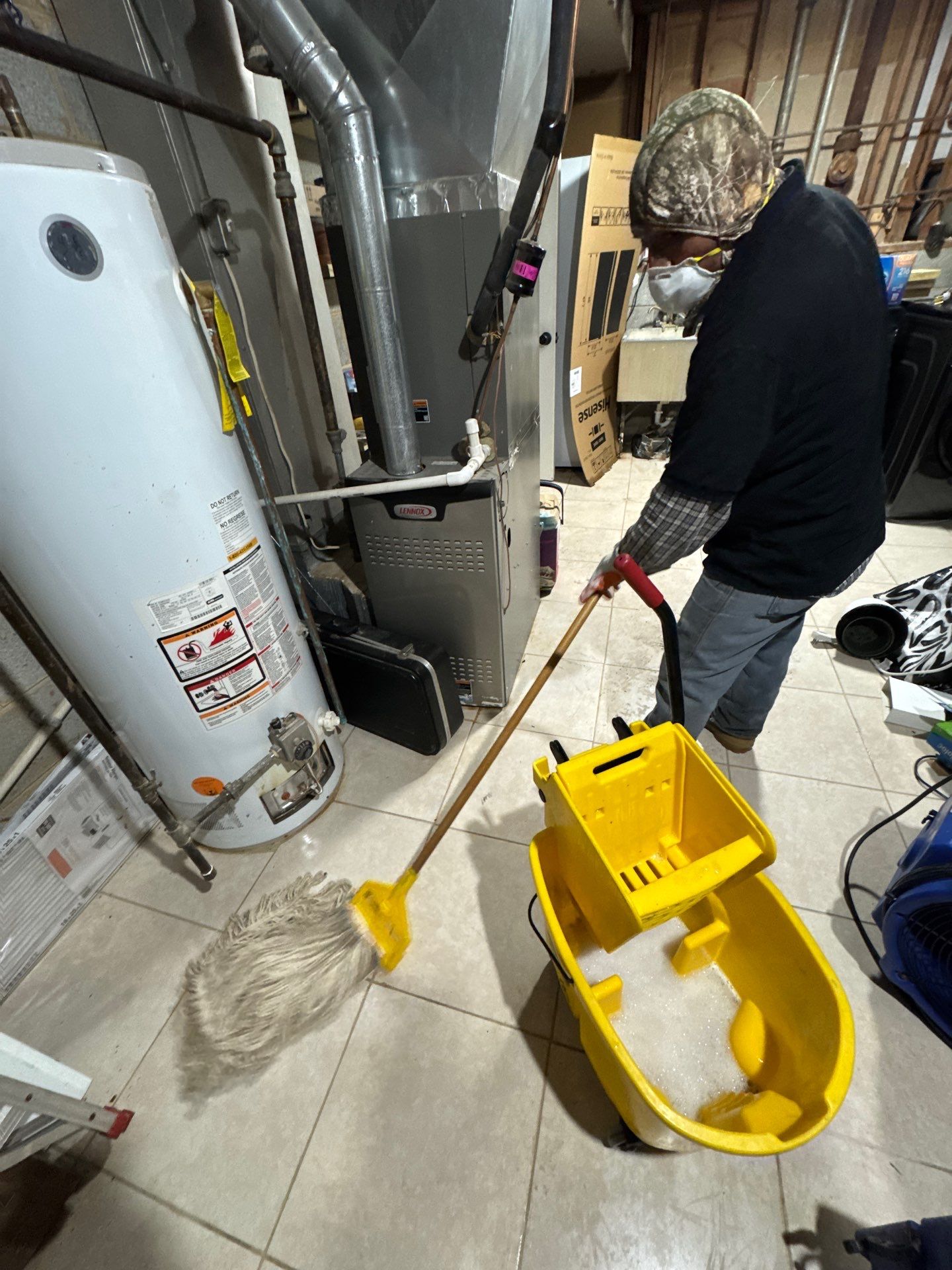 Mid-stage drying operation showing moisture extraction equipment and protected contents staged for remediation.