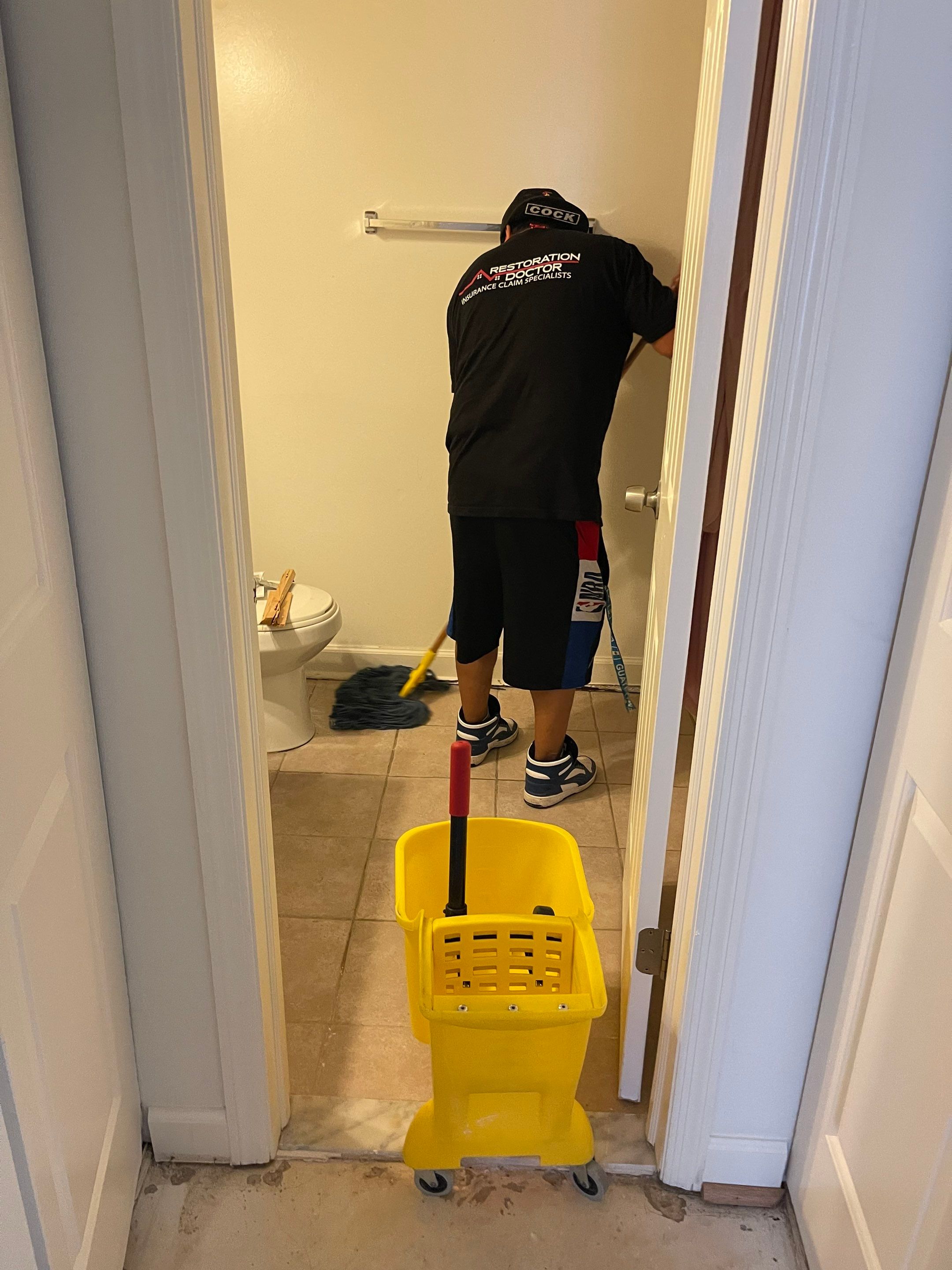 Standing water extraction underway in Gaithersburg water damage restoration, wet carpet and flooring visible.
