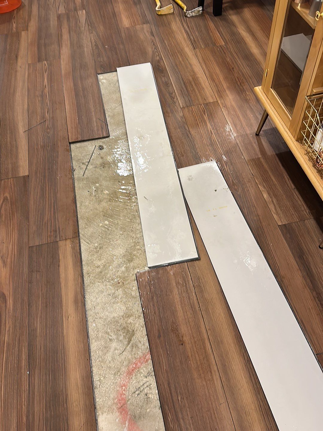 Standing water extraction underway in Gaithersburg water damage restoration, wet flooring visible.