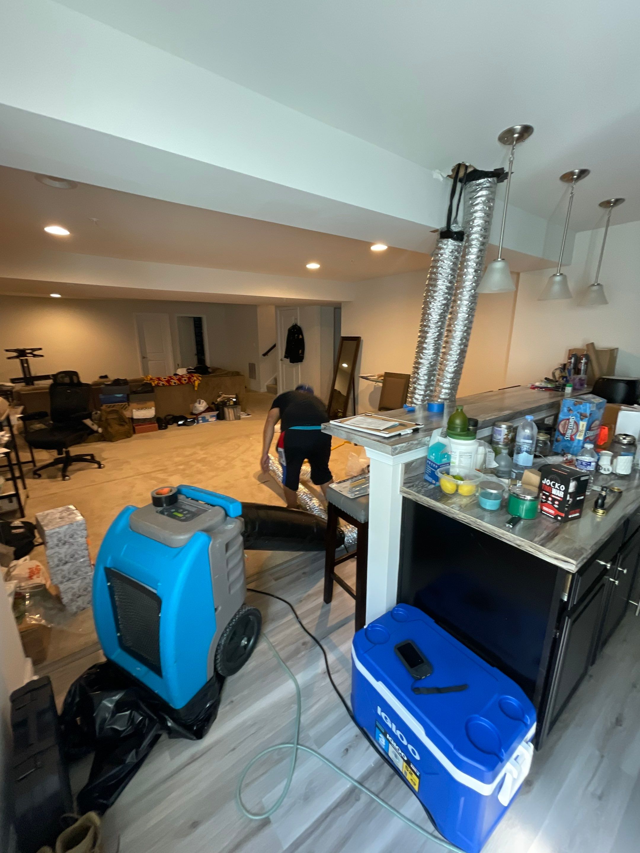 Standing water removal underway in Washington water damage restoration, extractors deployed across flooded interior.