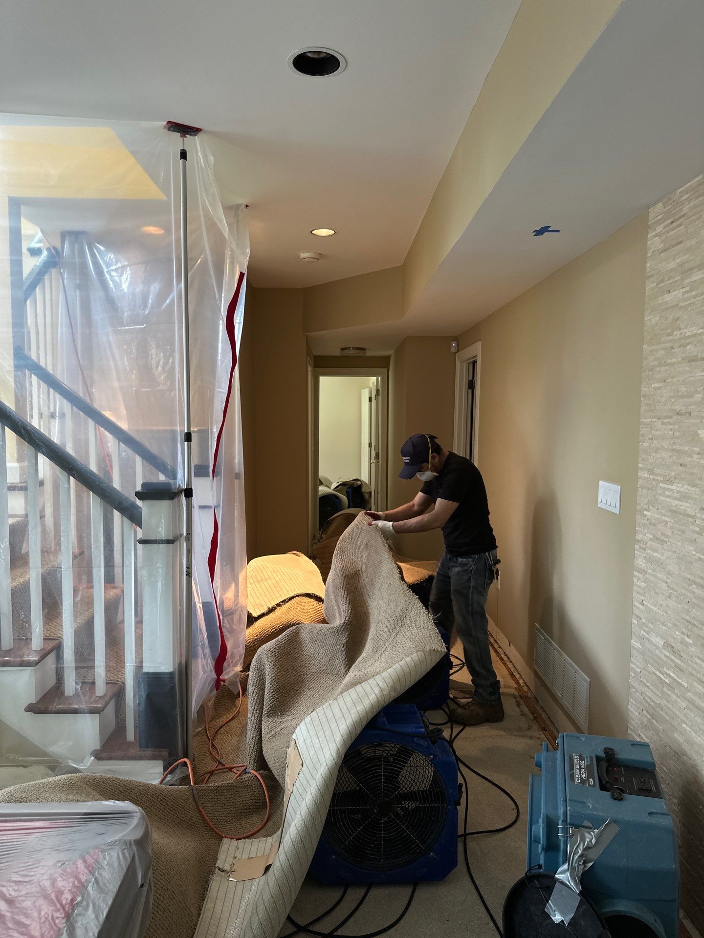 Structural drying equipment positioned to remove moisture from walls and subfloor after water removal.