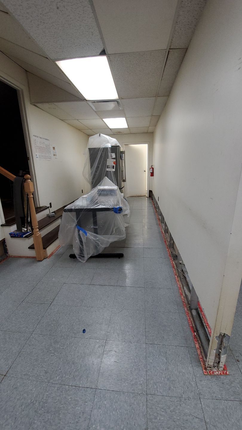Standing water extraction underway in Hyattsville water damage restoration, wet flooring visible.