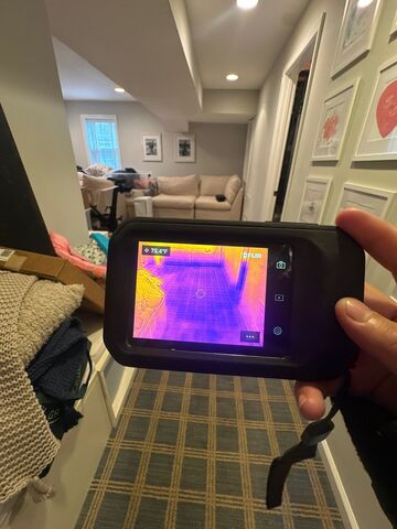 Thermal imaging moisture inspection during Kensington water restoration, equipment positioned for detection.