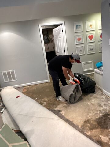Standing water extraction underway in Kensington water damage restoration, wet flooring visible.