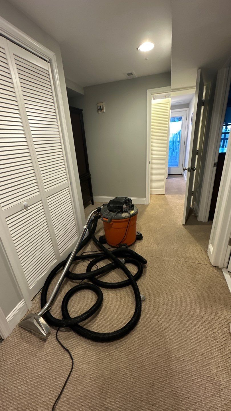 Standing water removal underway in Washington water damage restoration, extractors deployed across affected floor.
