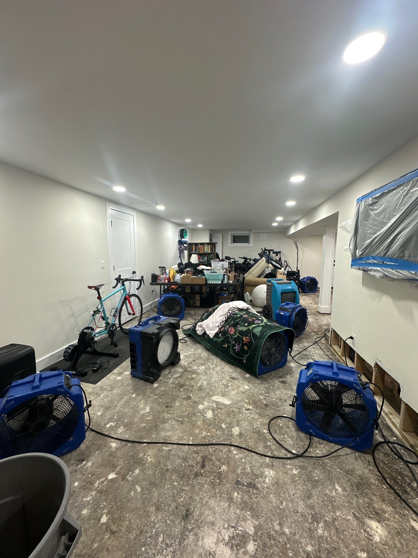 Flooring removal and remediation work progressing under containment barrier.