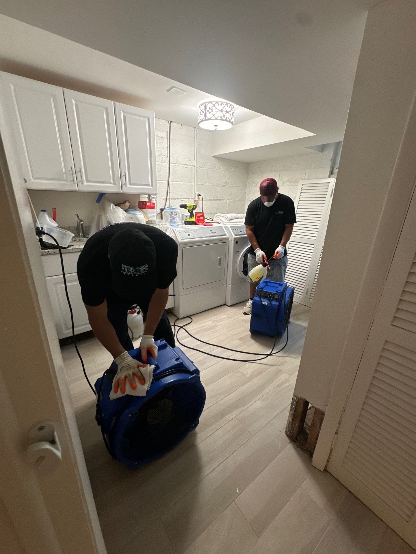 Standing water extraction underway in Bethesda water damage restoration, wet carpet and flooring visible.