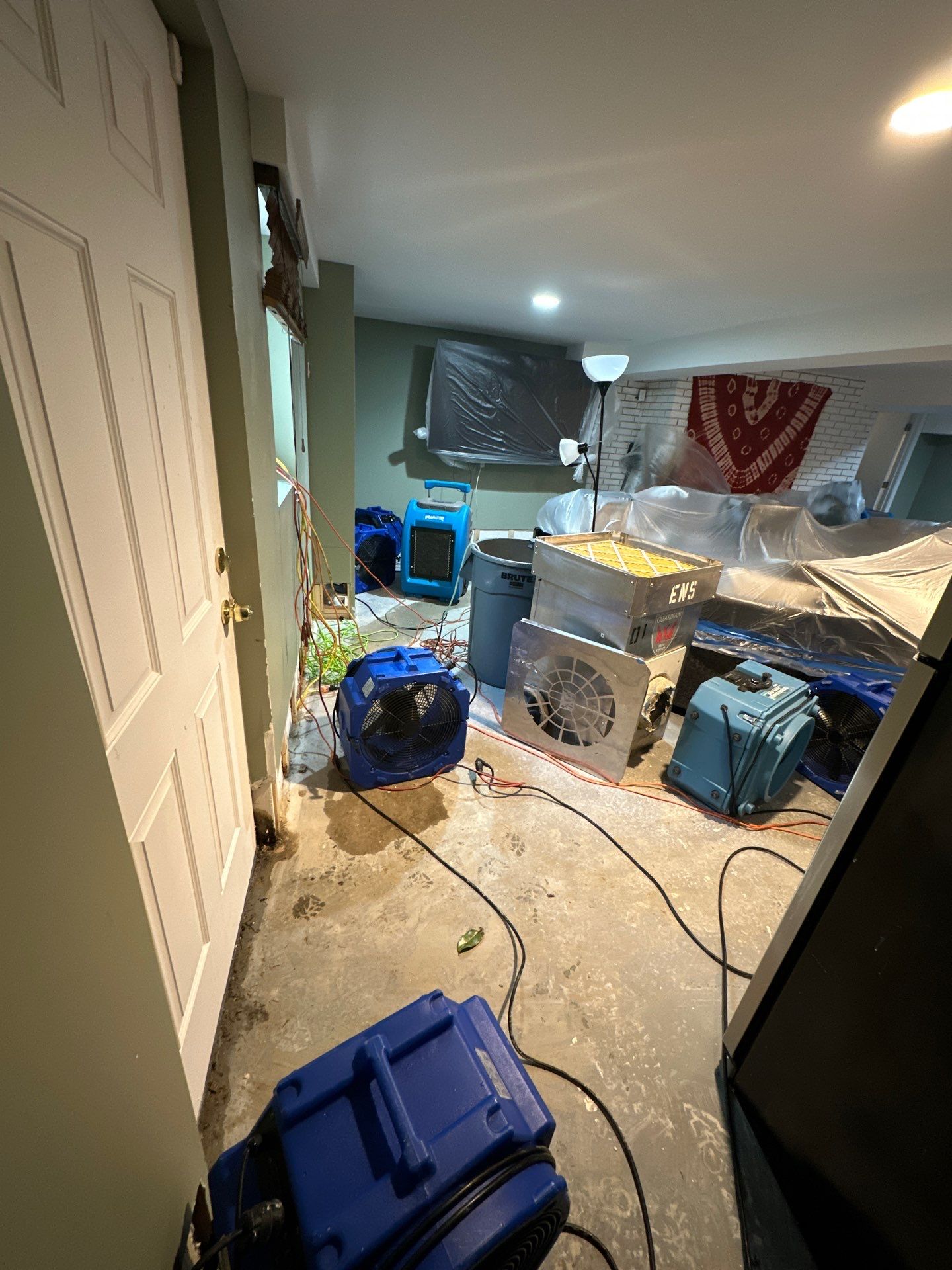Dehumidifiers and air movers deployed for moisture removal in water-damaged interior.