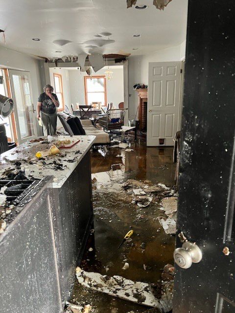 Standing water extraction underway in Frederick water damage restoration, wet flooring visible.