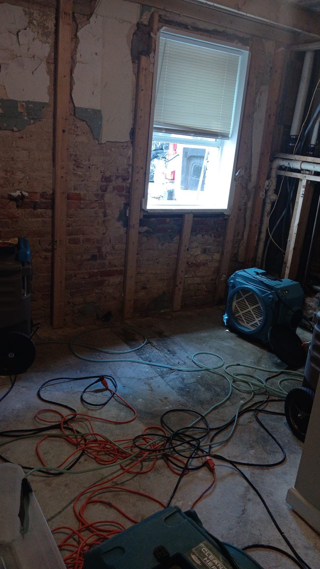 Standing water extraction underway in Washington water damage restoration, with industrial extractors removing pooled water from affected interior space.