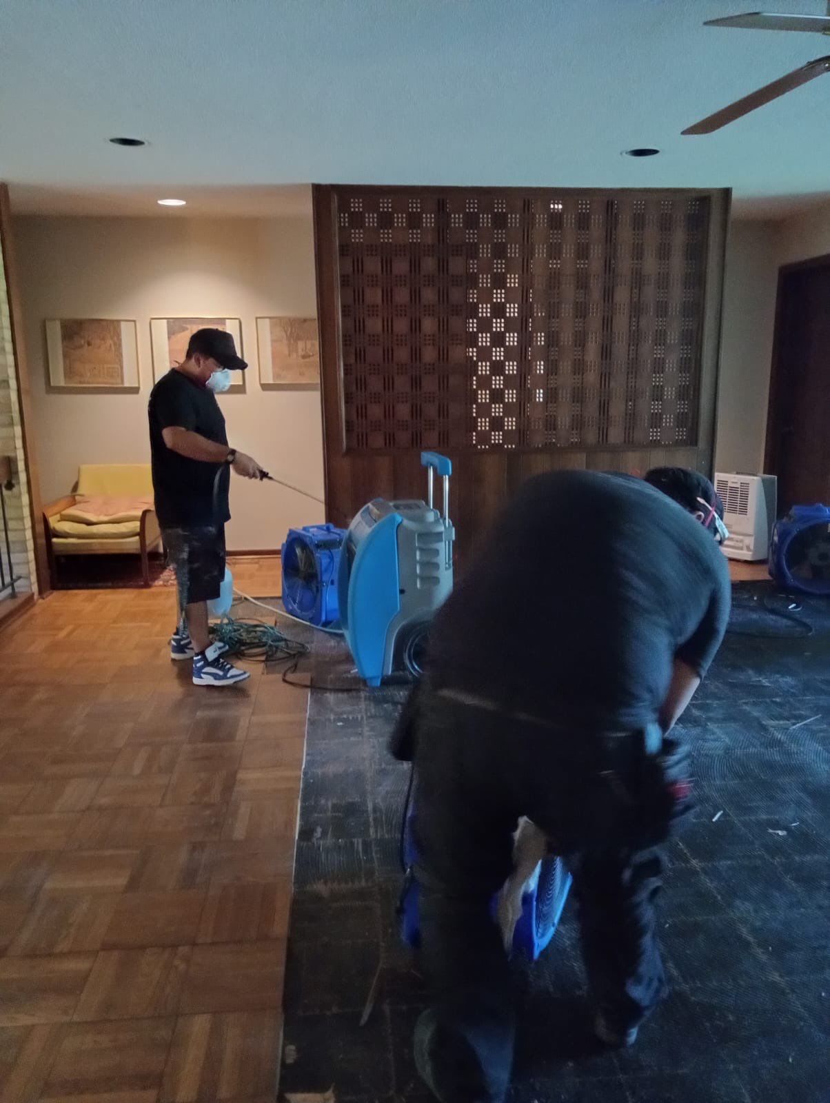 Dehumidifier and air movers positioned during structural drying phase of water damage restoration.