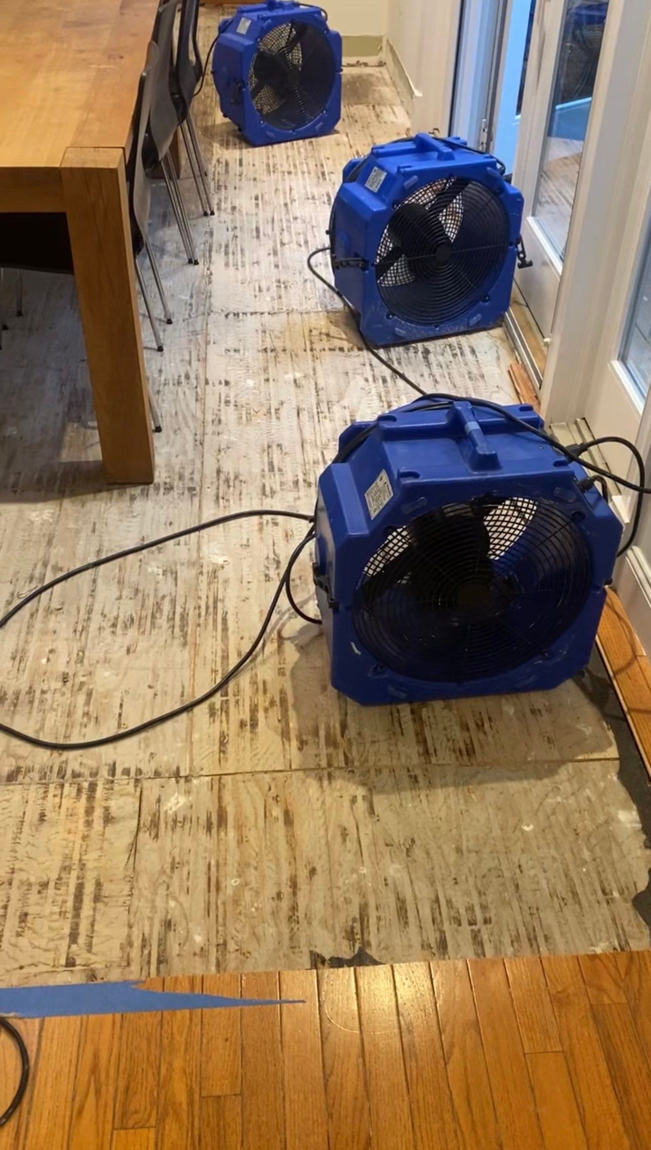 Standing water removal underway in Washington water damage restoration, extractors deployed across affected floor.