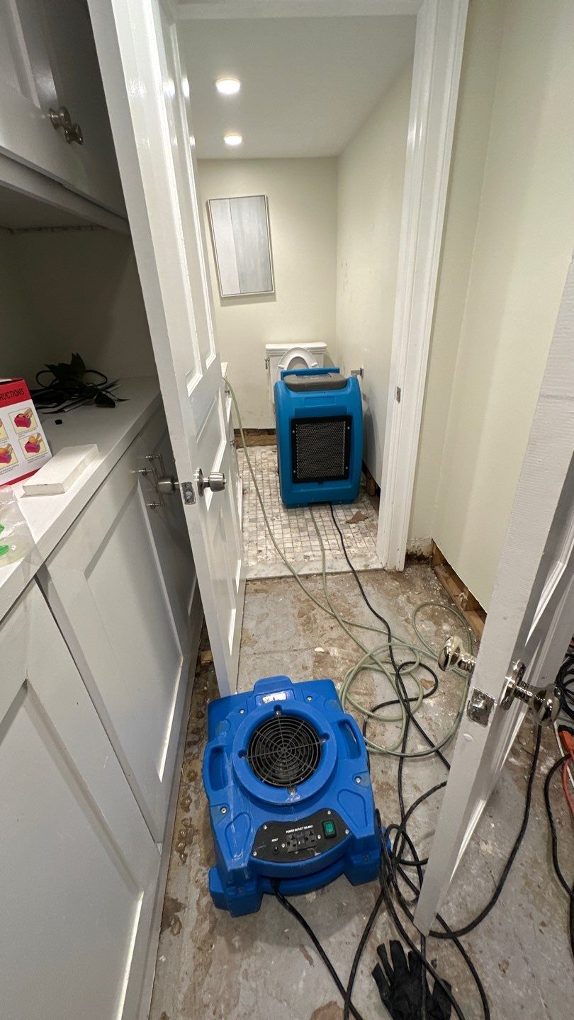Standing water extraction underway in Washington home during water damage restoration assessment.