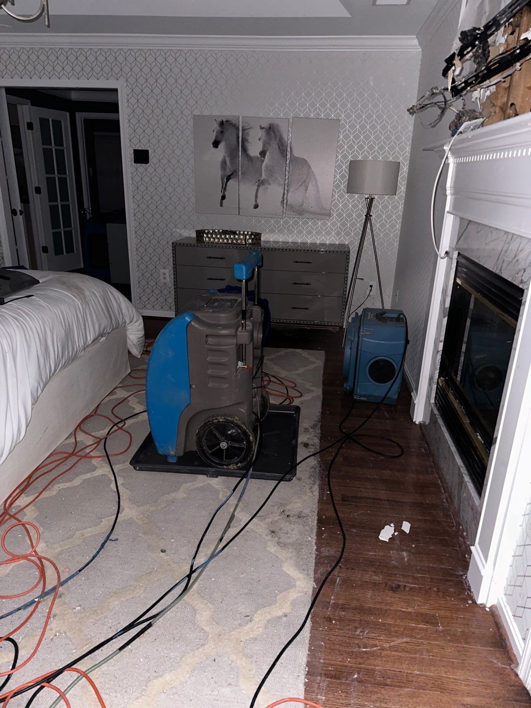 Structural drying in progress with air movers and dehumidifiers working to pull moisture from building materials.