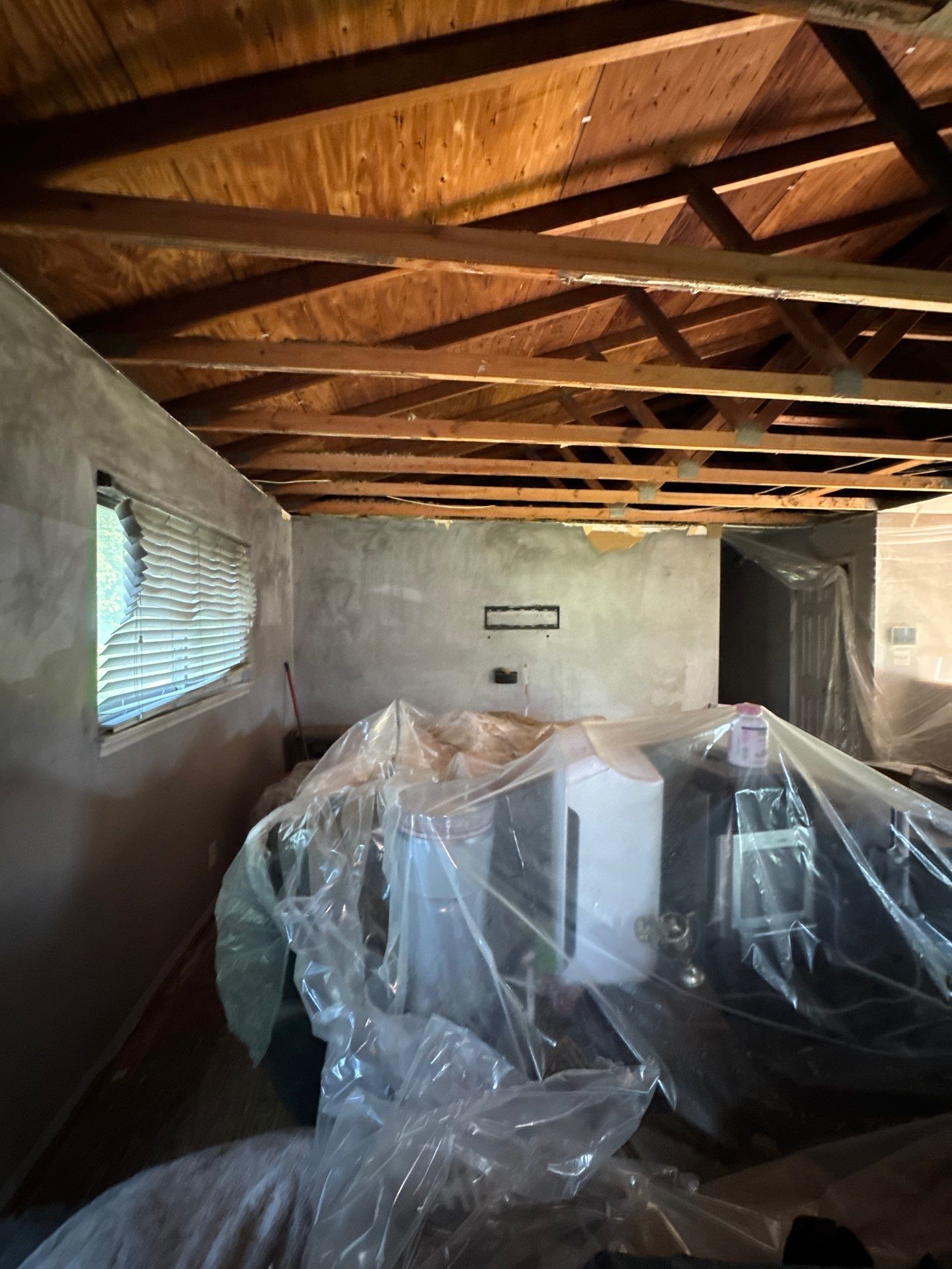 Ceiling repair in progress during odor removal work, with affected material preparation underway.