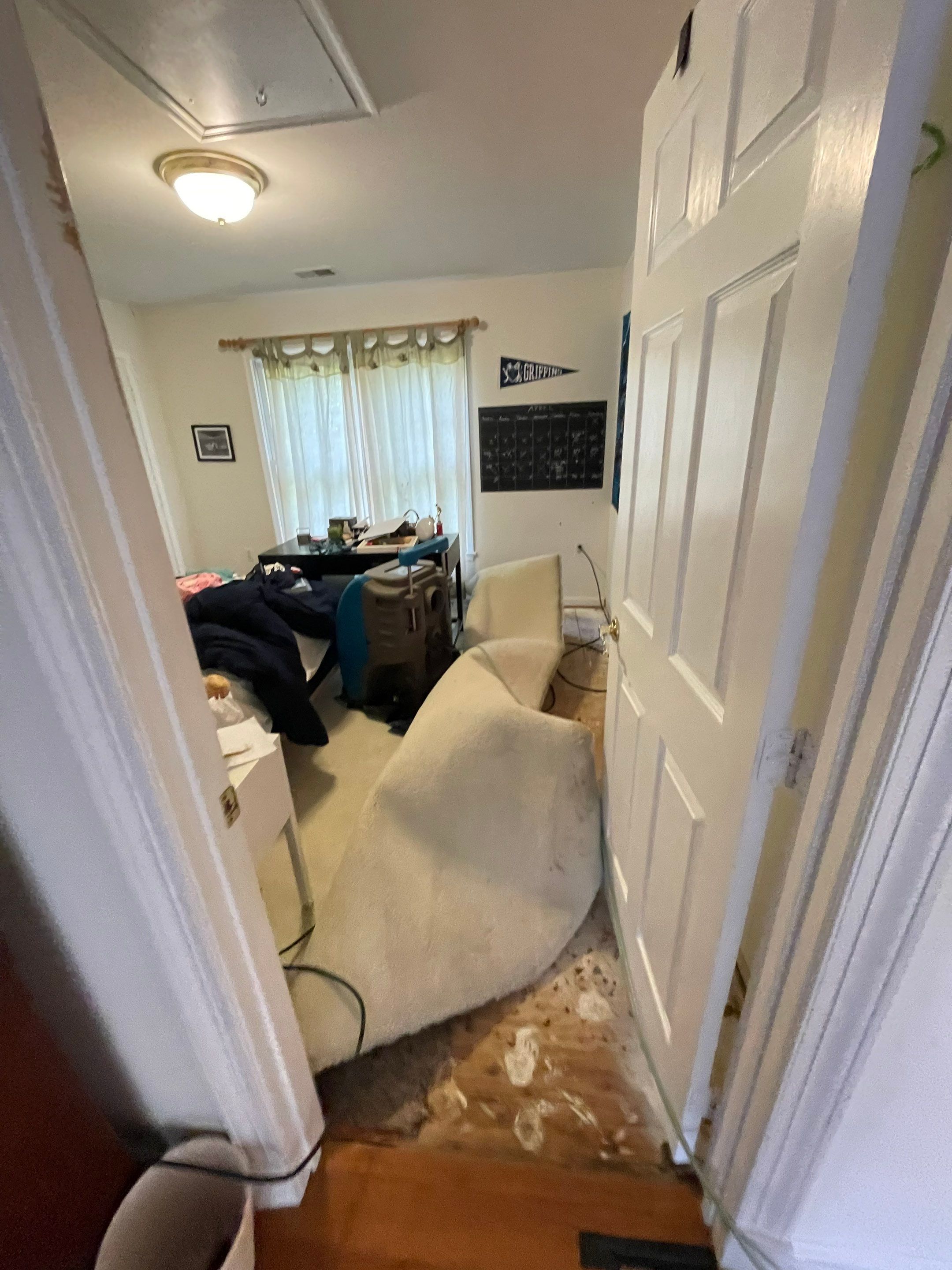 Standing water extraction underway in Washington water damage restoration, wet flooring visible.