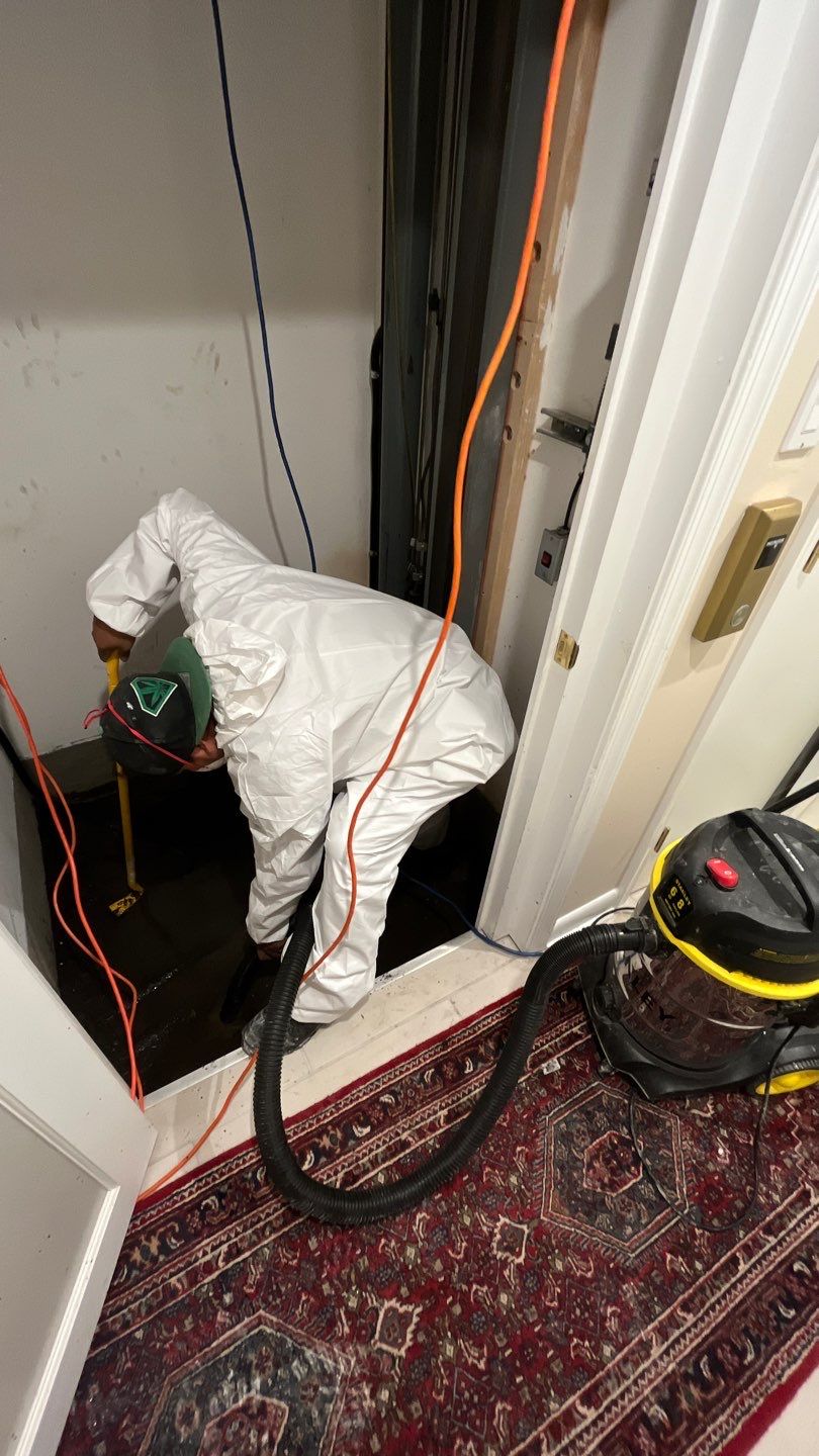 Standing water extraction begins in Washington water damage restoration, removing pooled water from affected interior space.