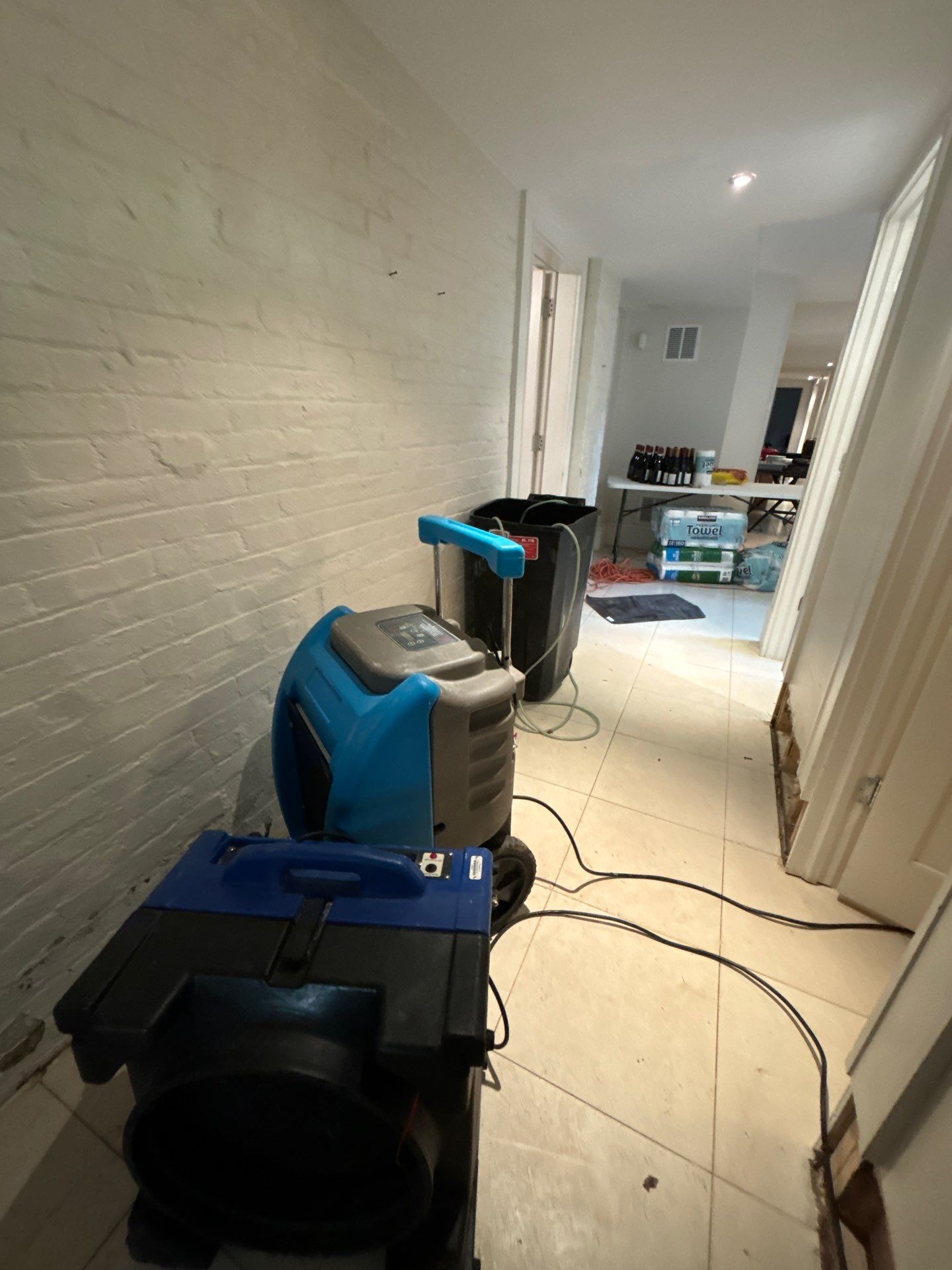 Mid-stage drying setup showing equipment placement and moisture management during active restoration of water-damaged space.