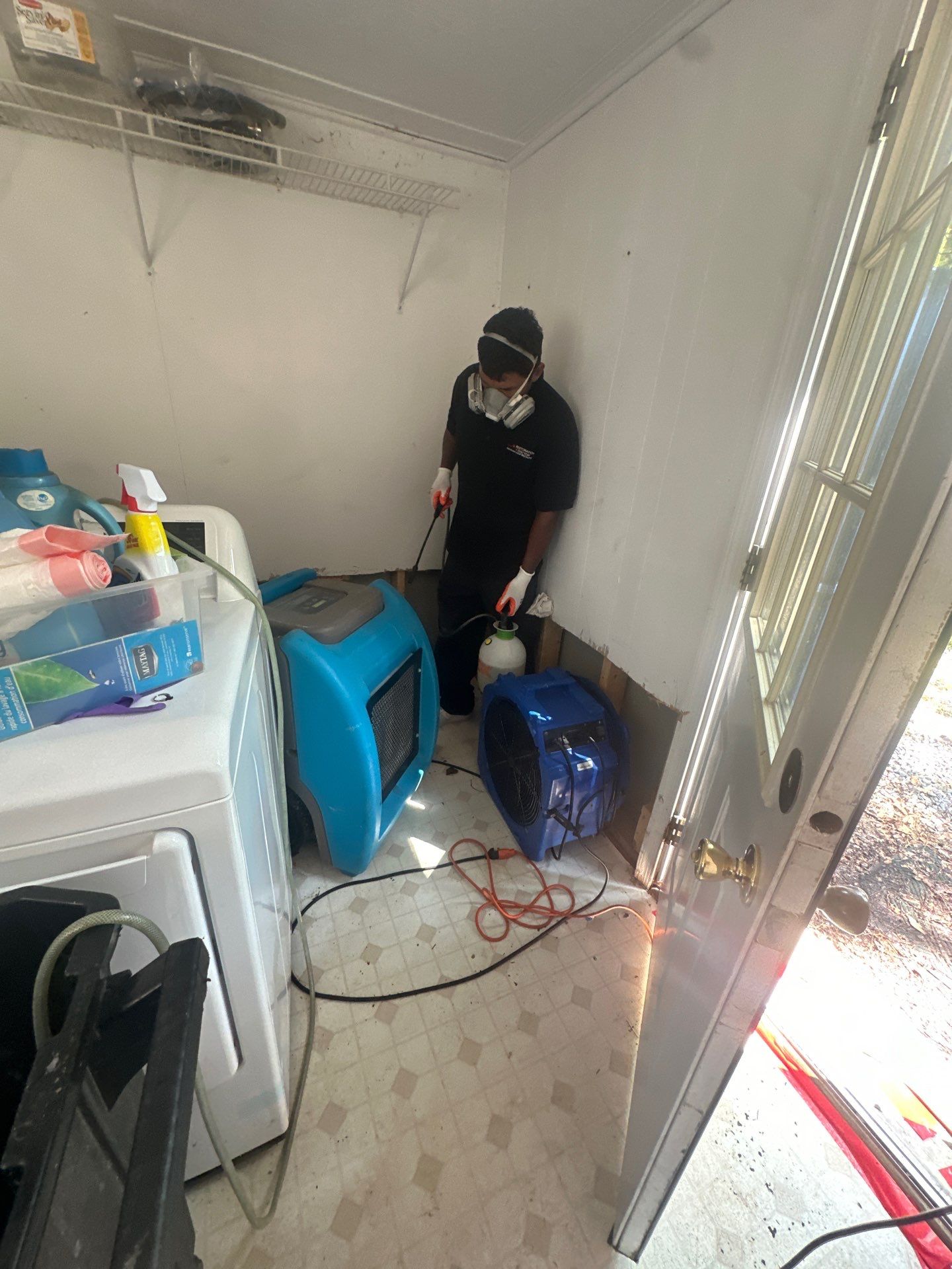 Water damage restoration in Colesville: dehumidifier and drying equipment positioned in affected room during initial assessment.