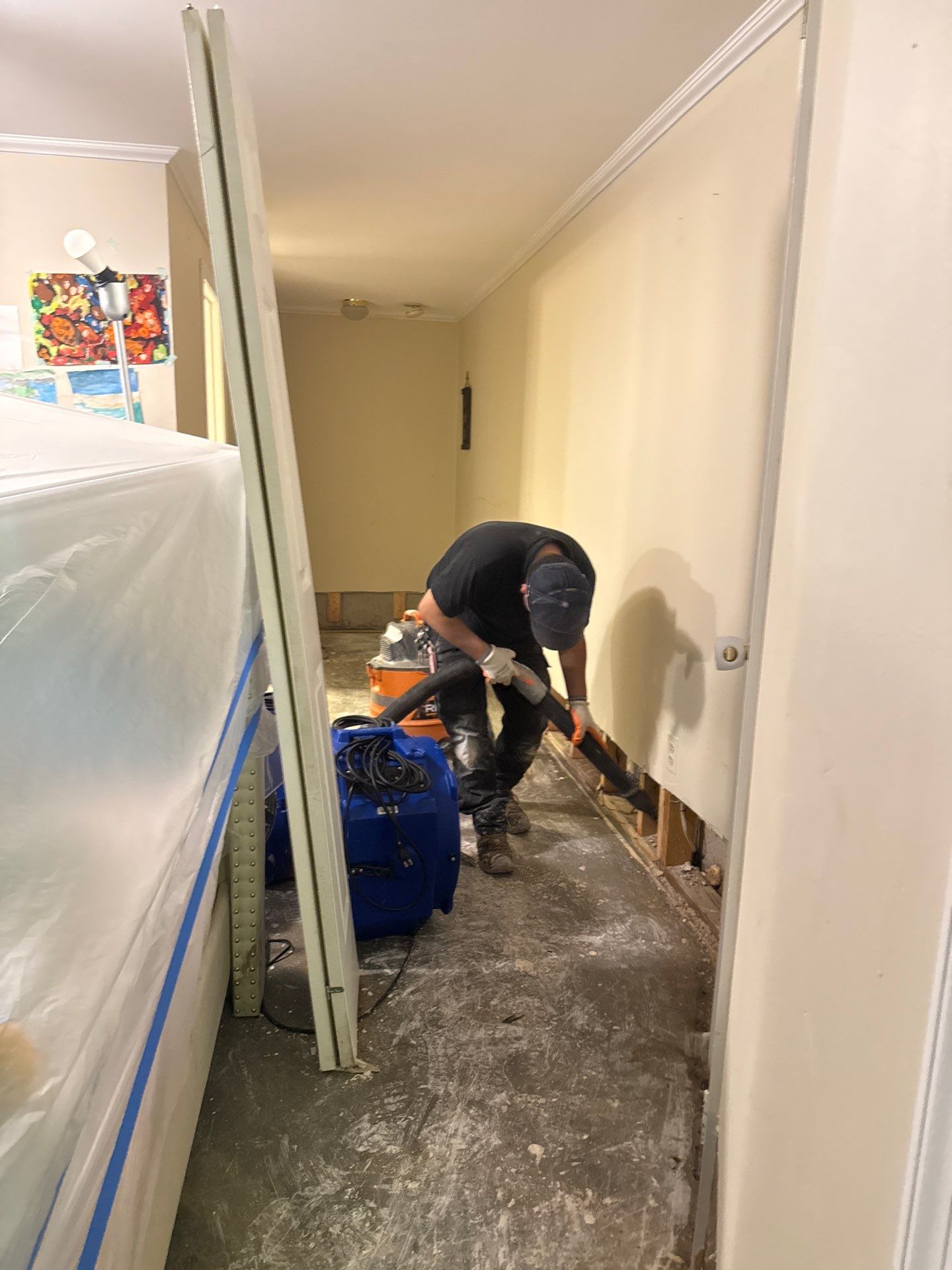 Dehumidifier and air movers positioned for structural drying during water damage mitigation.