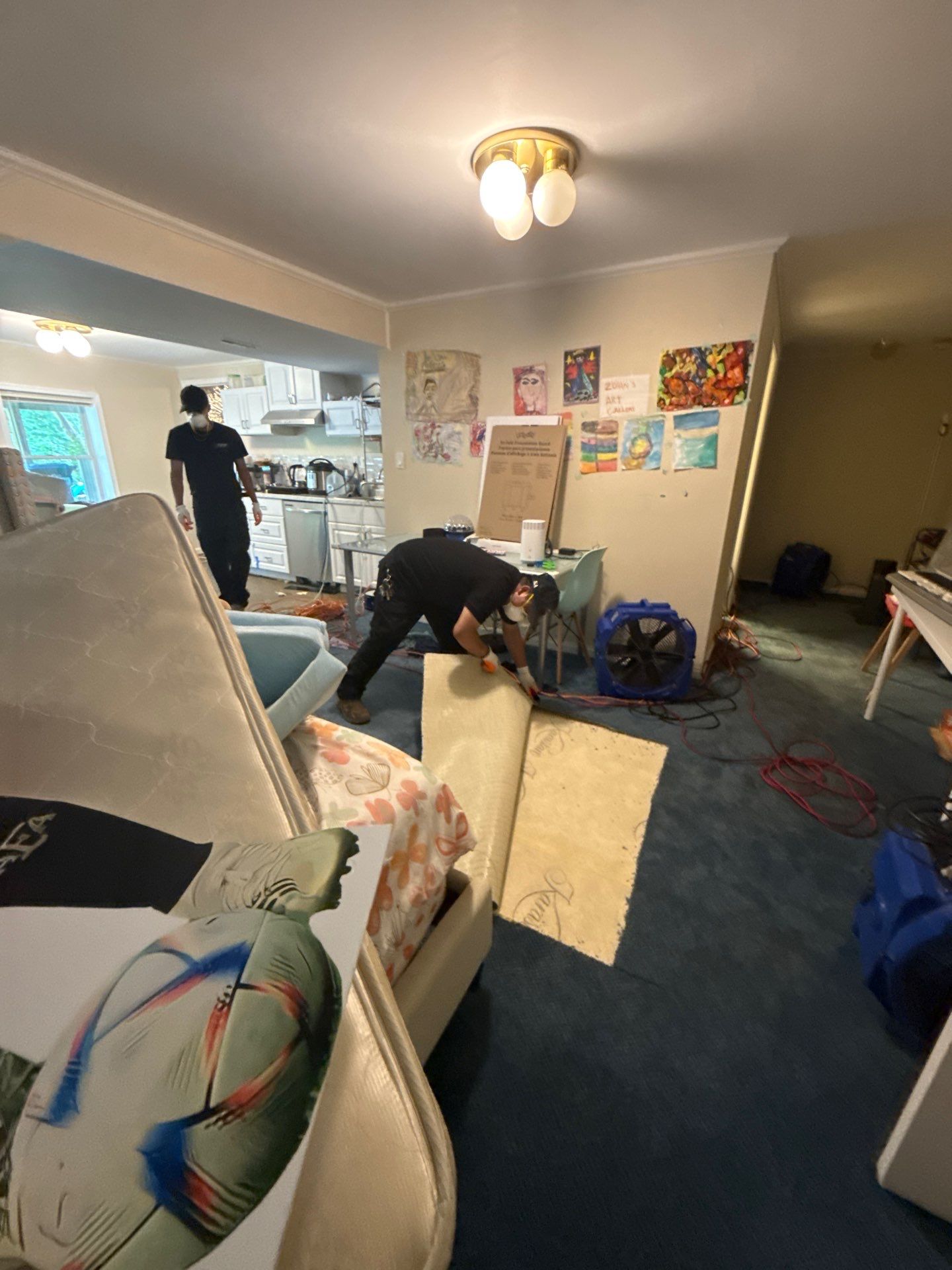 Drying equipment monitoring moisture levels in walls and subfloor during restoration work.