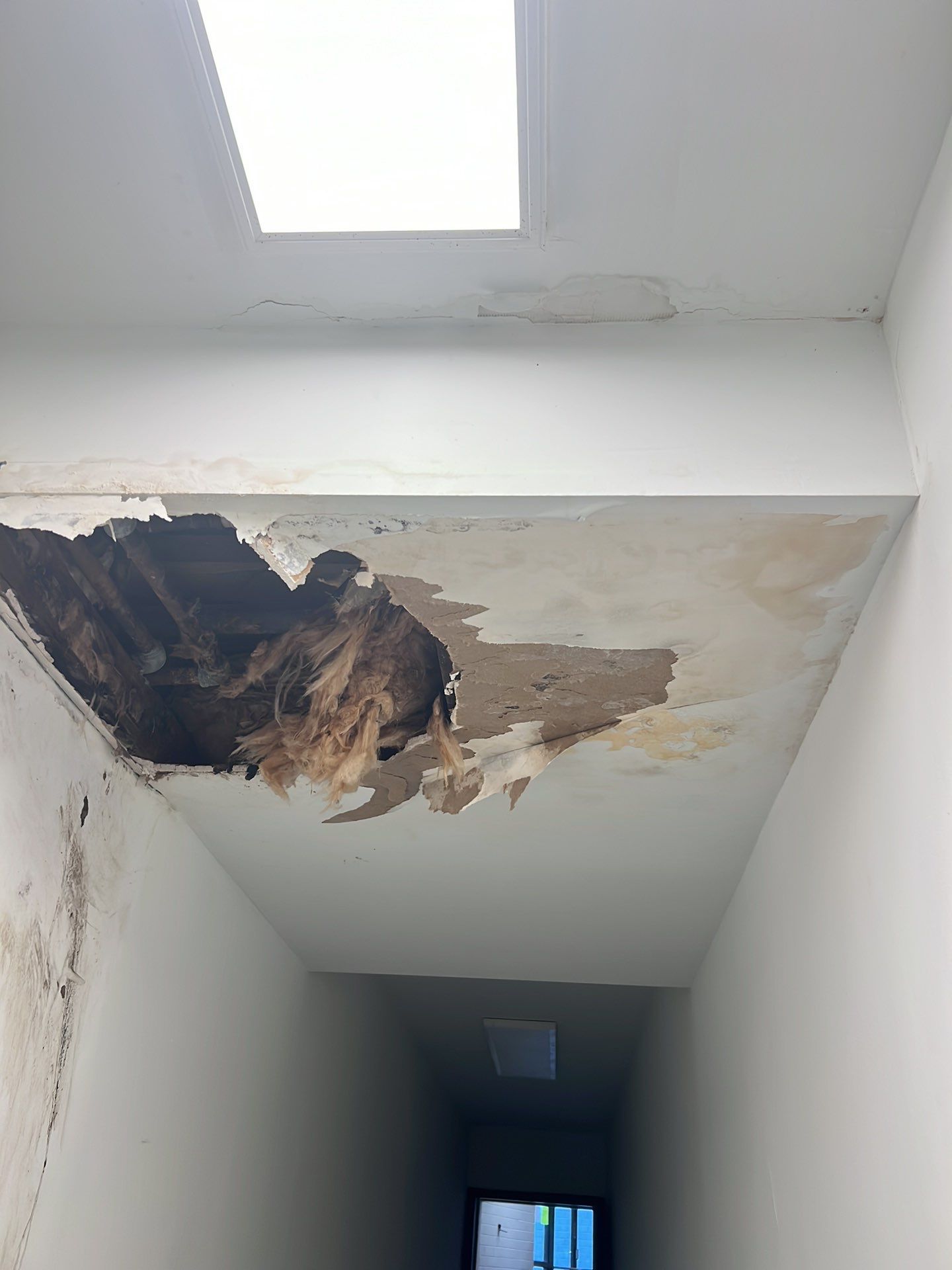 Continued drying operations with equipment monitoring moisture levels in structural materials.