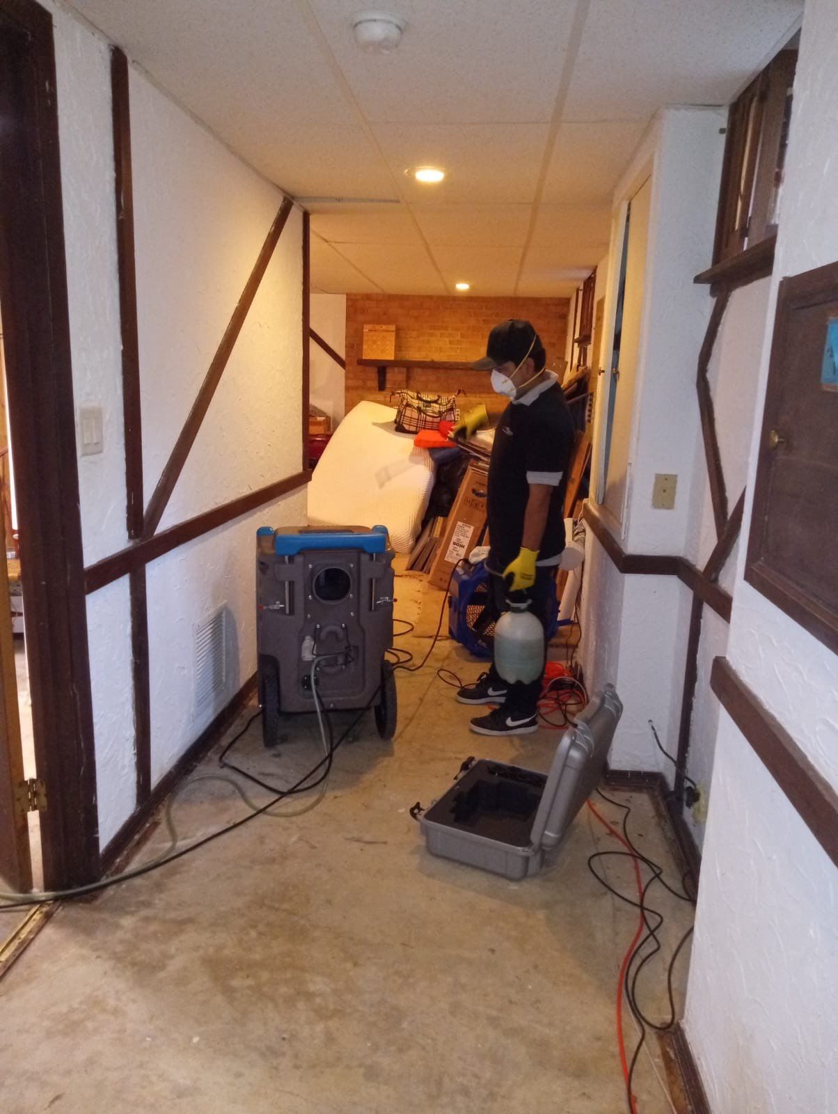 Structural drying in progress with multiple air movers and dehumidifiers managing moisture removal from building materials.