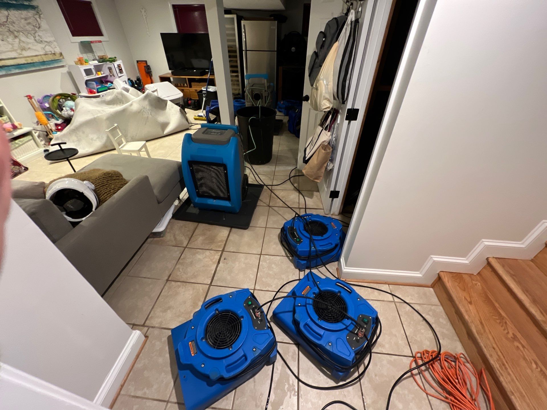 Standing water removal underway in Washington water damage restoration, extractors deployed across affected floor.