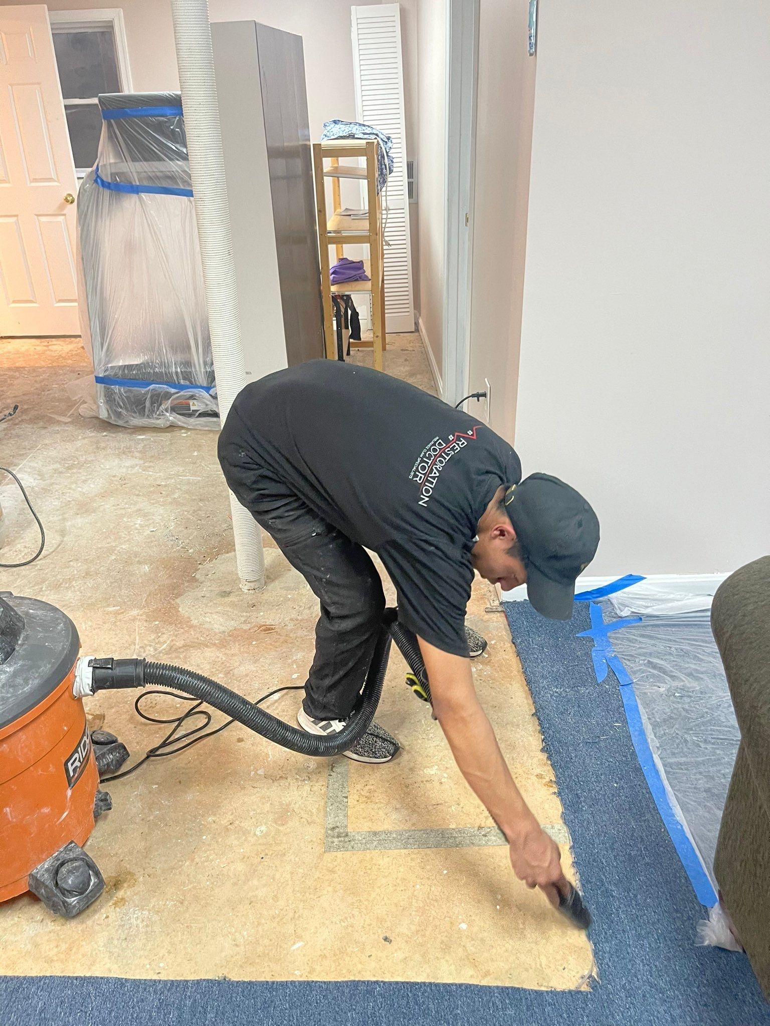 Mid-stage water removal showing extracted flooring materials staged for remediation and drying.